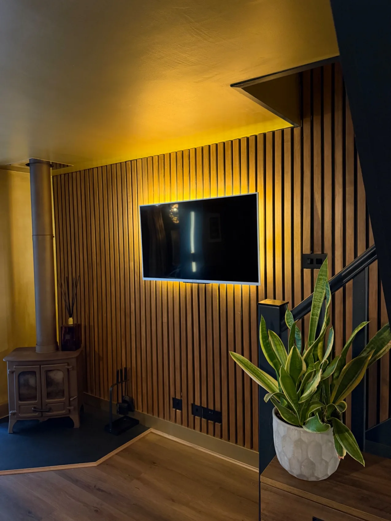 Cosy living room with wood-burning stove and timber feature wall