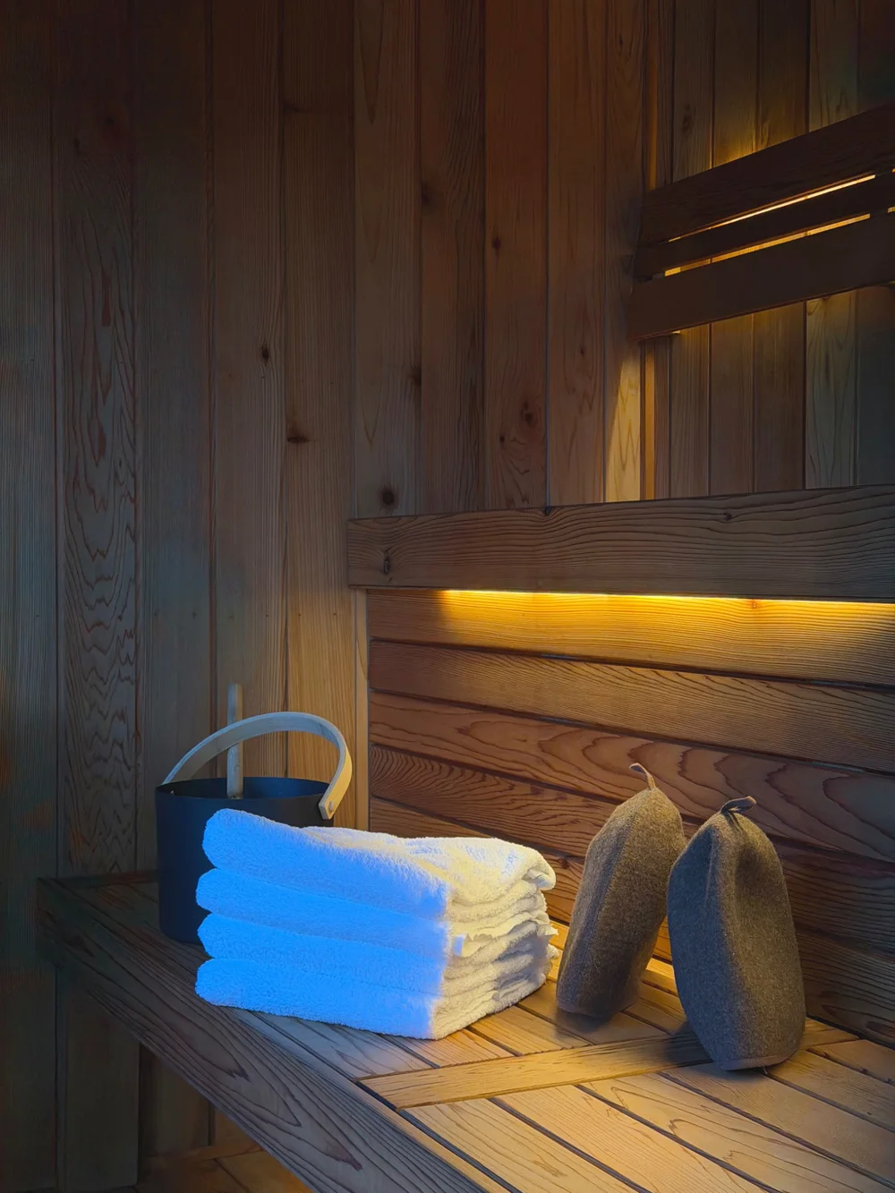 Cedar-lined sauna interior with warm lighting and timber benches